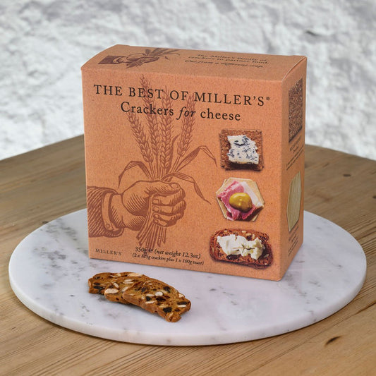 Box of Miller's crackers for cheese on a marble coaster with crackers beside it.