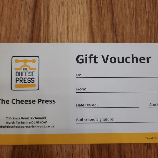 Gift voucher from The Cheese Press on a wooden surface