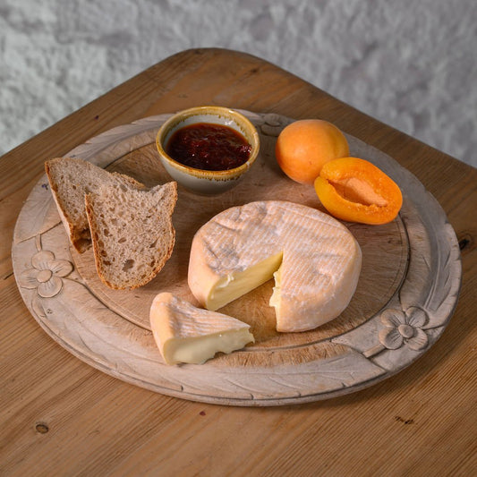 Yarlington cheese with bread, apricots and chutney on a wooden board