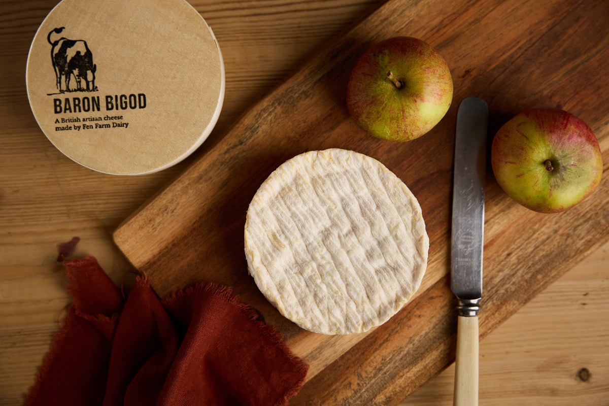 Baron Bigod artisan cheese with apples on a wooden cheeseboard