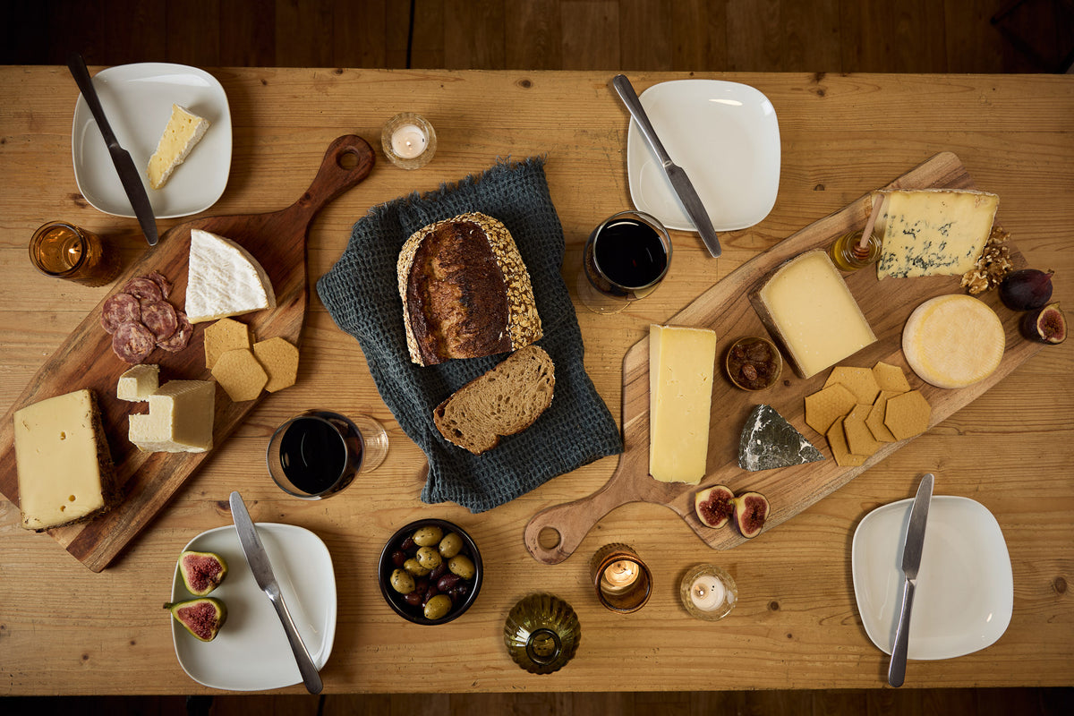 Artisan cheese and charcuterie spread with bread, crackers, olives, figs and red wine