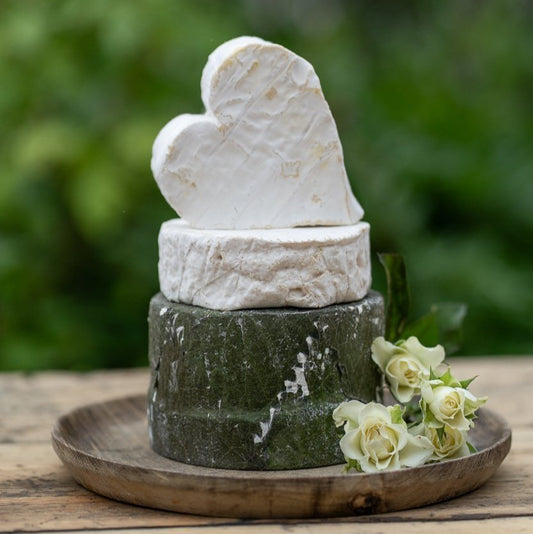 Three-tier celebration cheese cake decorated with white roses